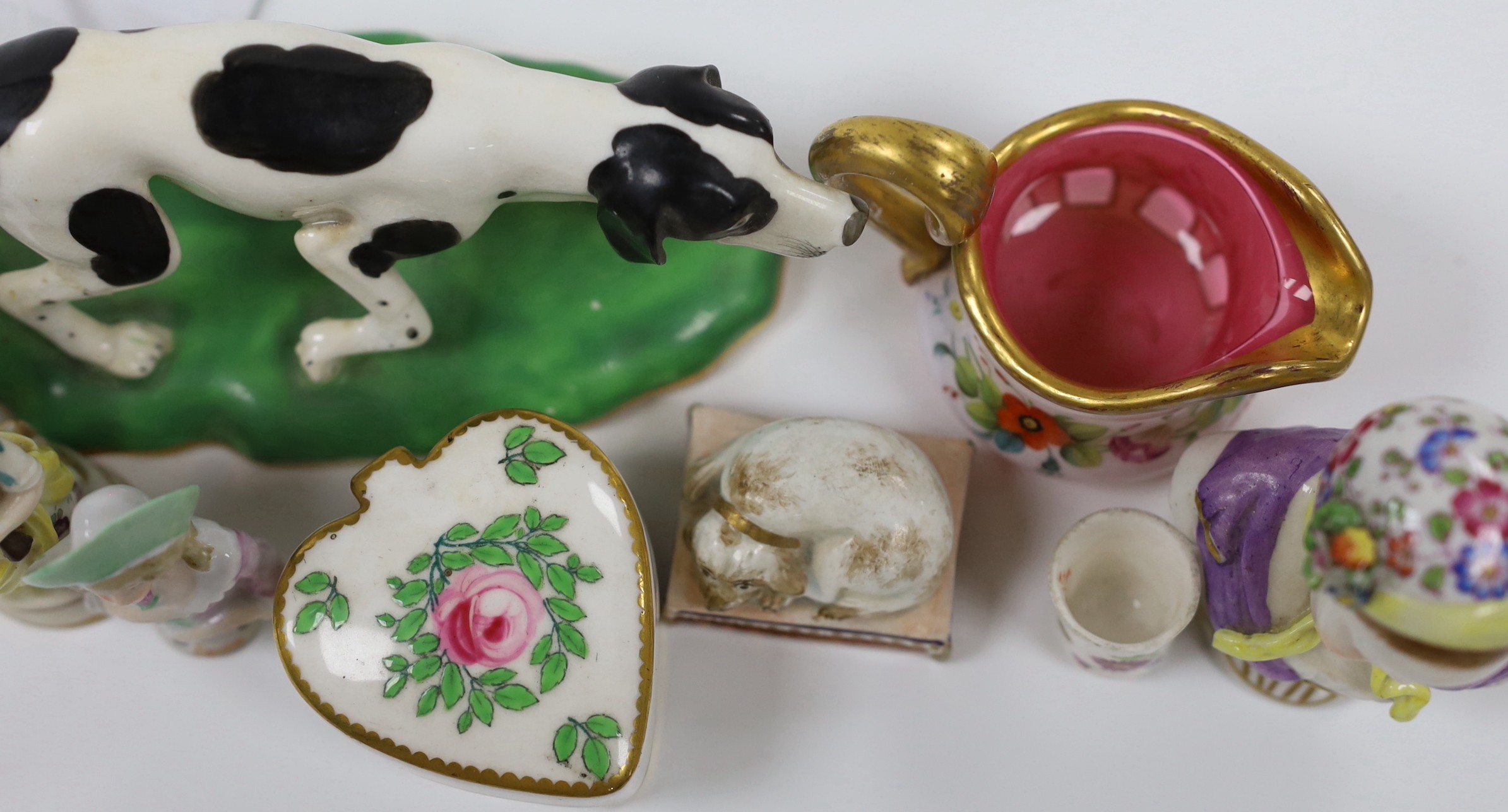 An early 19th century earthenware sleeping dog, a Victorian bone china model of a dog, a miniature overlaid glass decanter and ewer, etc. (12)